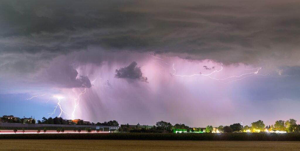 lightning bolts over dark storm clouds at night
